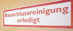 Schild mit der Aufschrift „Bauschlussreinigung erledigt“ an gelber Wand.
